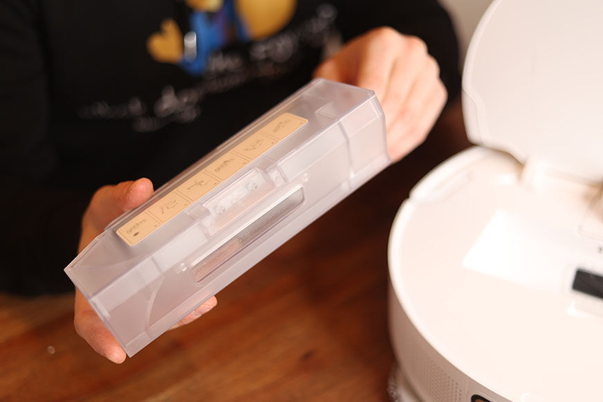 The mobile dust bin of the Dreame L10s Ultra is held up.